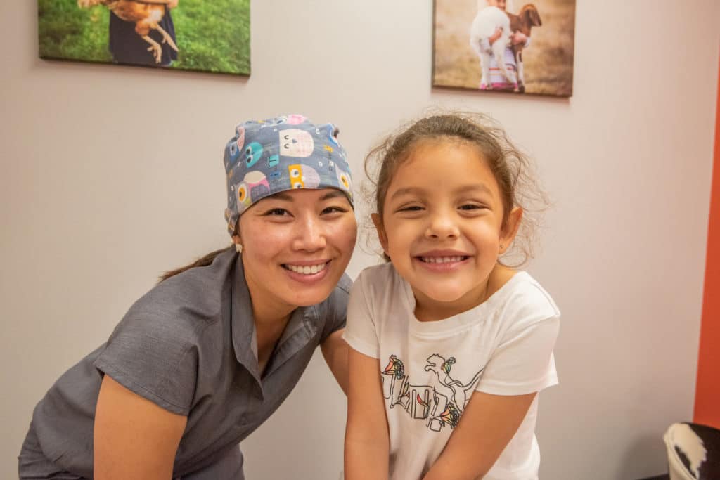 pediatric dentist with a child at her dental office